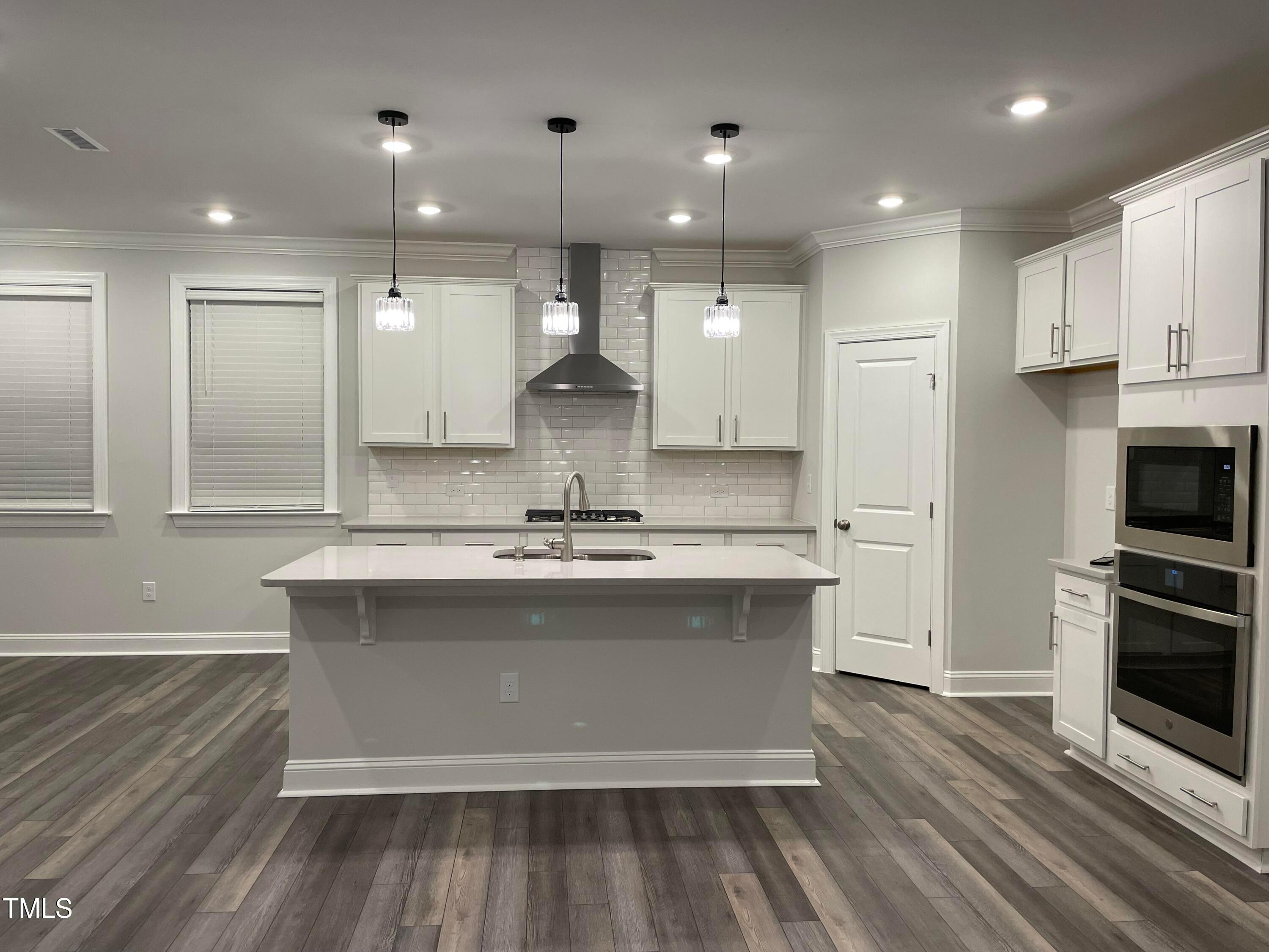308 Edge Of Auburn Boulevard Raleigh, NC 27610 - Photo 7 of 23 a large kitchen with a large counter top a sink stainless steel appliances and cabinets