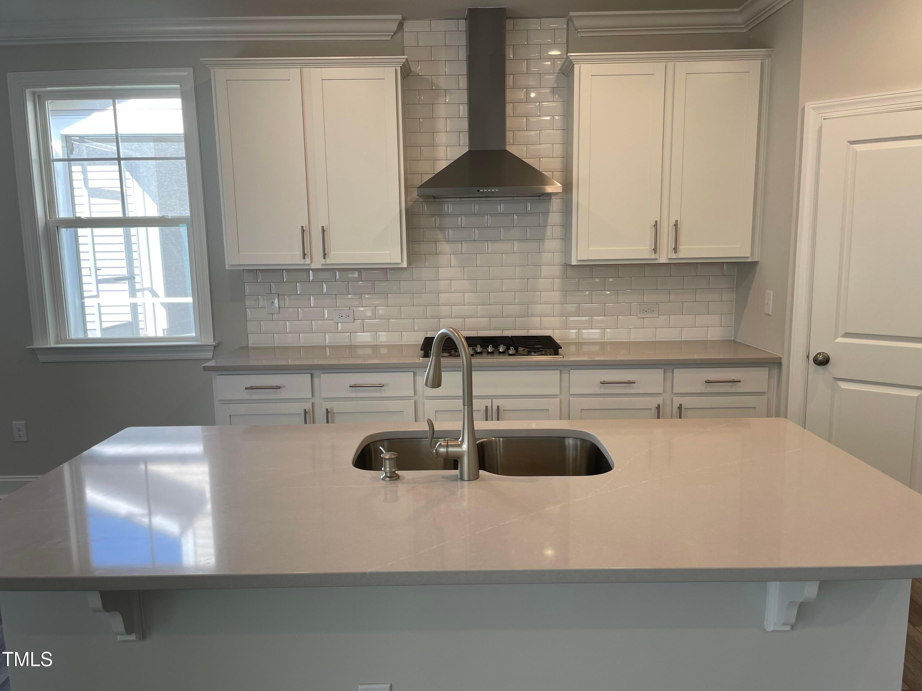 308 Edge Of Auburn Boulevard Raleigh, NC 27610 - Photo 9 of 23 a kitchen with a sink a stove and white cabinets