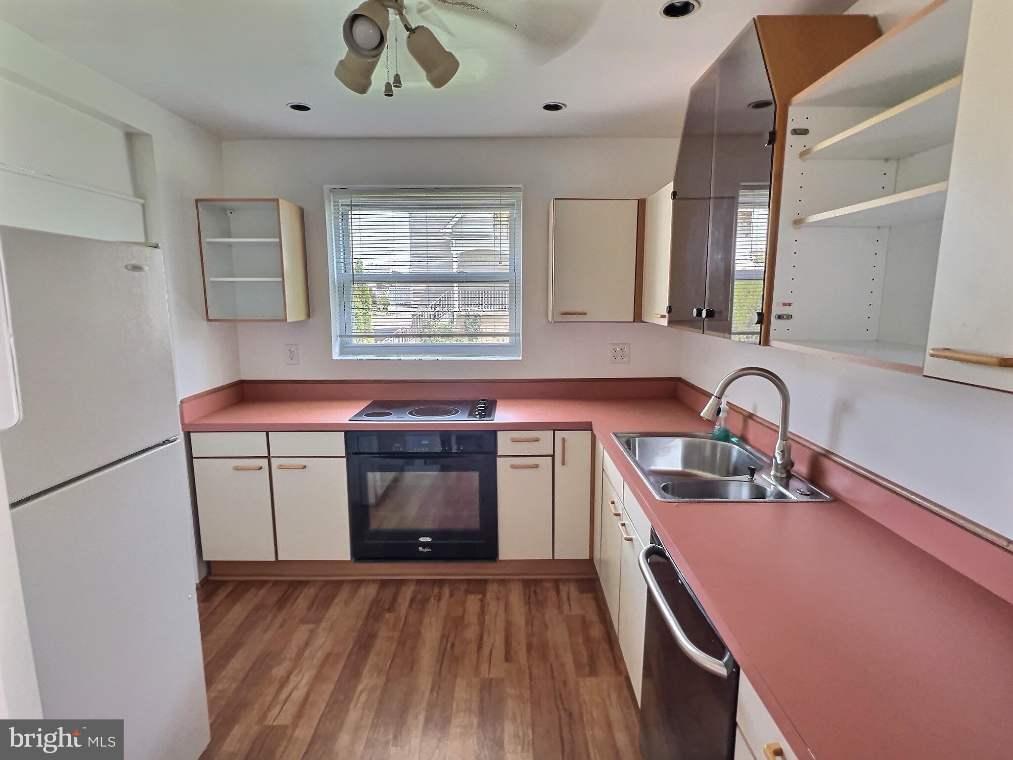 9015 Cuckold Point Road Baltimore, MD 21219 - Photo 7 of 12 a kitchen with stainless steel appliances granite countertop a sink and a stove top oven with wooden floor