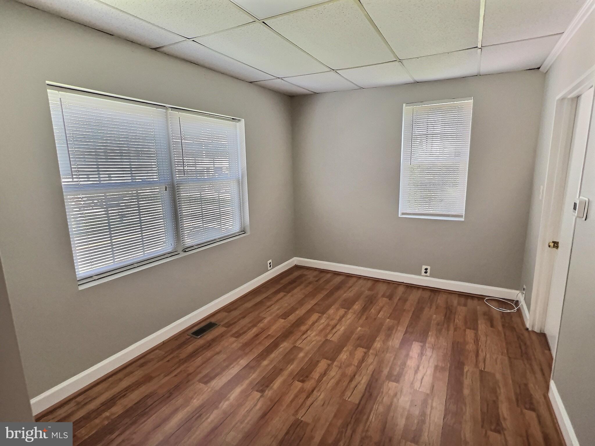 9015 Cuckold Point Road Baltimore, MD 21219 - Photo 8 of 12 a view of an empty room with wooden floor and a window
