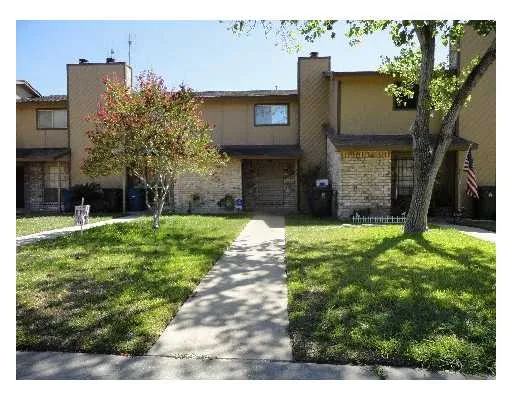 a view of a house with brick walls and a yard with plants