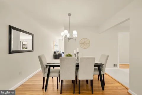 a view of a dining room with furniture a chandelier and wooden floor