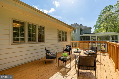 a view of a deck with table and chairs with wooden floor and fence