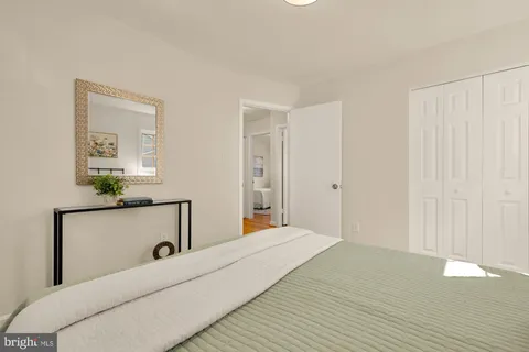 a bedroom with a bed and a lamp on dresser