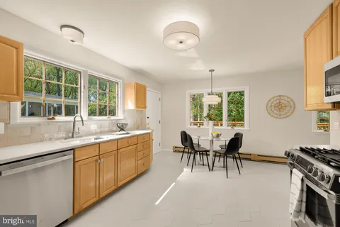 a dining room with furniture a large window and wooden floor