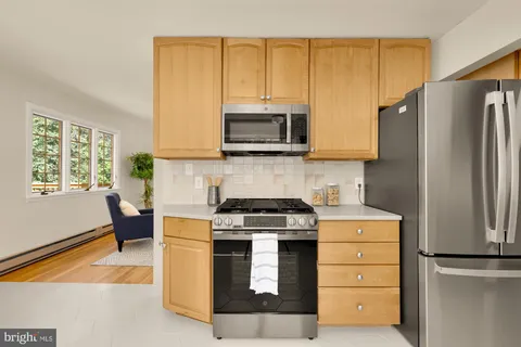 a kitchen with stainless steel appliances granite countertop a stove a refrigerator and a microwave