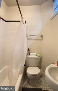a white toilet sitting next to a bath tub and a sink