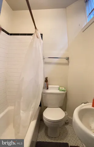 a white toilet sitting next to a bath tub and a sink
