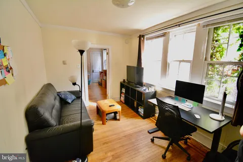 a livingroom with workspace and a couch