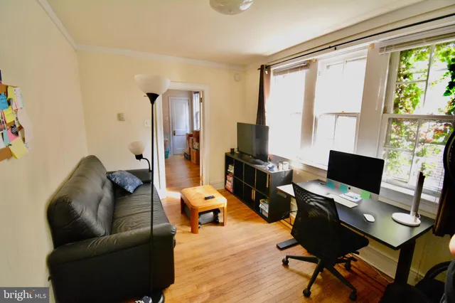 a livingroom with workspace and a couch