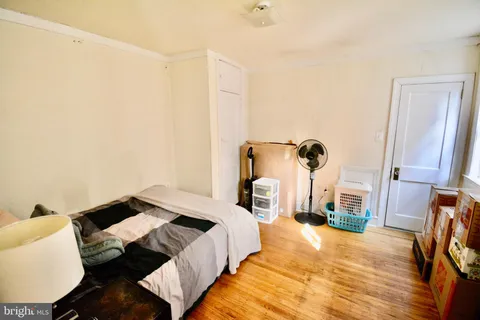 a bedroom with a bed and wooden floor