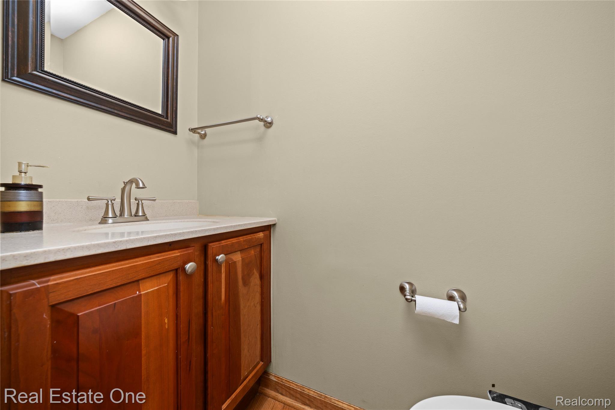 39750 Cheviot Road Canton, MI 48188 - Photo 28 of 71 Wood-finish vanity with panel doors, light-toned countertop, integrated sink, and brushed nickel faucet