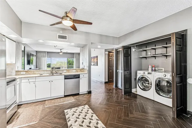 an aerial view of a city with lots of residential buildings ocean and mountain view in back