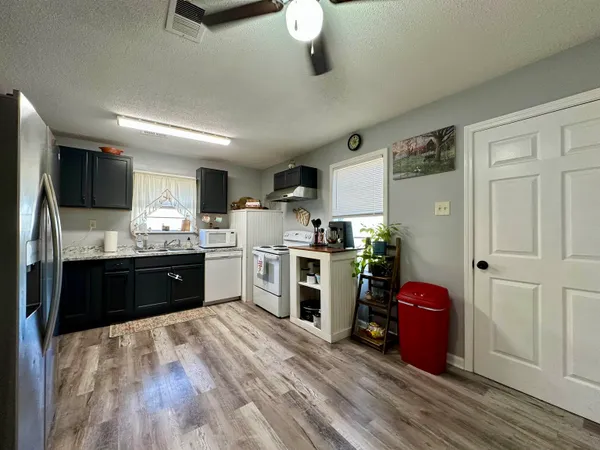 a kitchen with stainless steel appliances a sink cabinets and wooden floor
