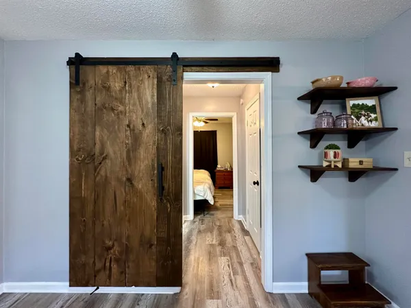 a view of a hallway with wooden floor and closet