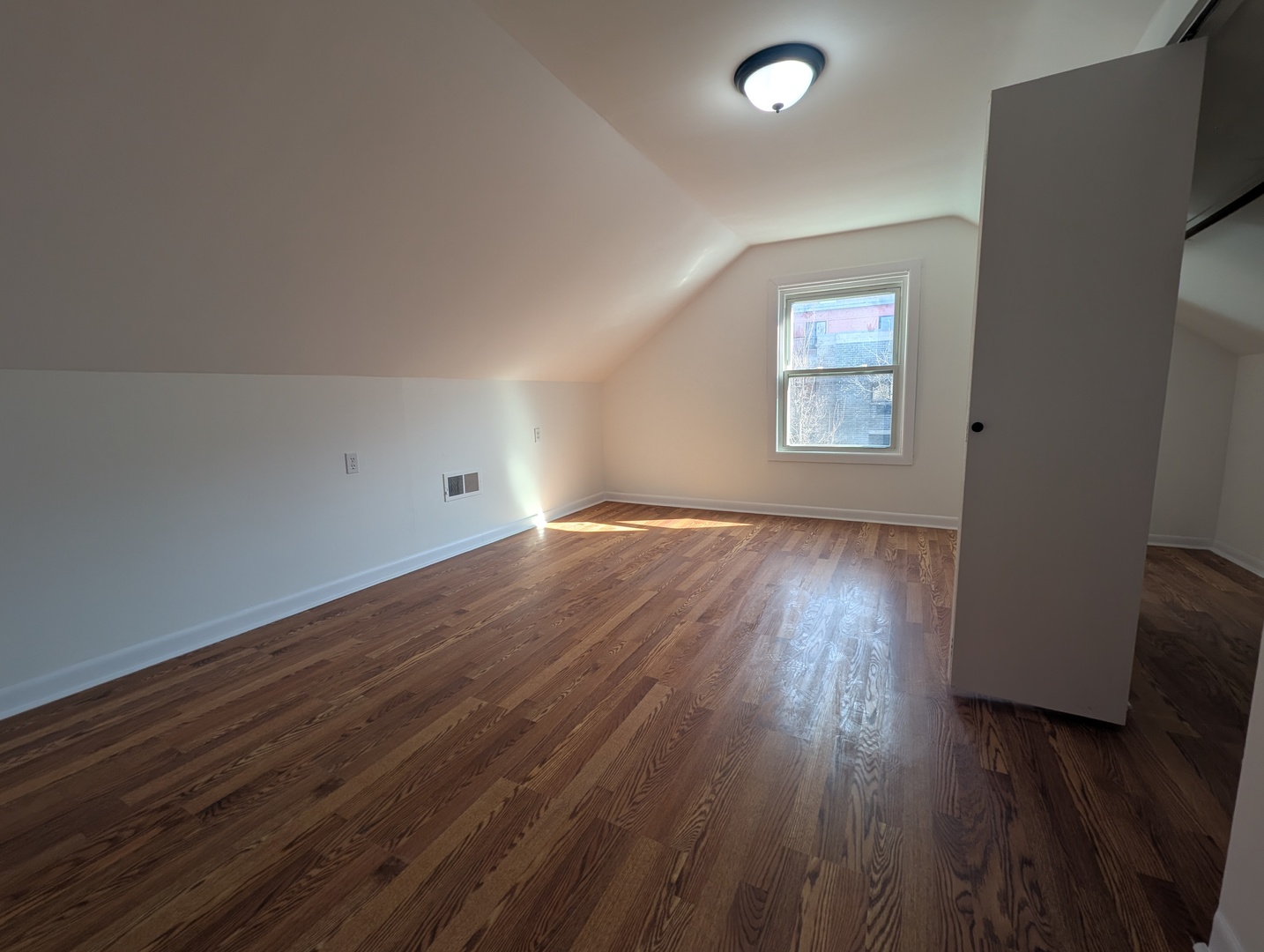 1520 West Melrose Street, Unit 2F Chicago, IL 60657 - Photo 7 of 16 an empty room with wooden floor and windows