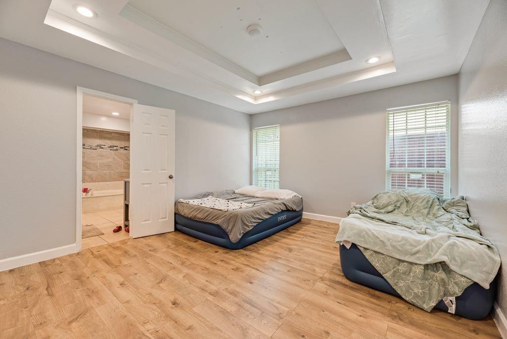 5114 Ben Davis Road Sachse, TX 75048 - Photo 23 of 28 Spacious room featuring wood-finish flooring, recessed lighting, and a tray ceiling