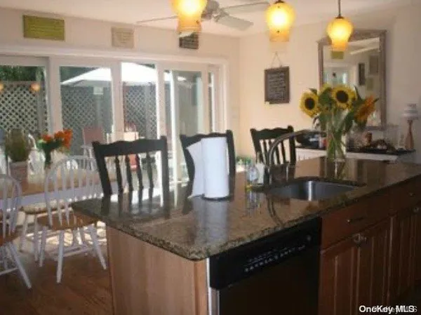a kitchen with granite countertop a table chairs and couches