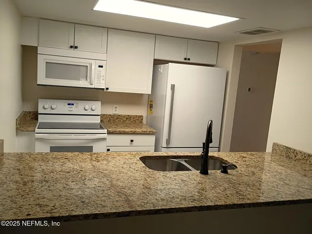a kitchen with kitchen island a sink a stove and refrigerator