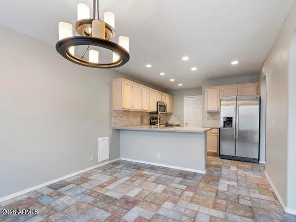 a kitchen with stainless steel appliances granite countertop a sink a stove a refrigerator cabinets and a dining table