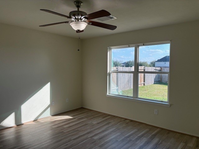 2819 Back Bay Brook Trail Houston, TX 77045 - Photo 3 of 16 a view of an empty room with a window and wooden floor