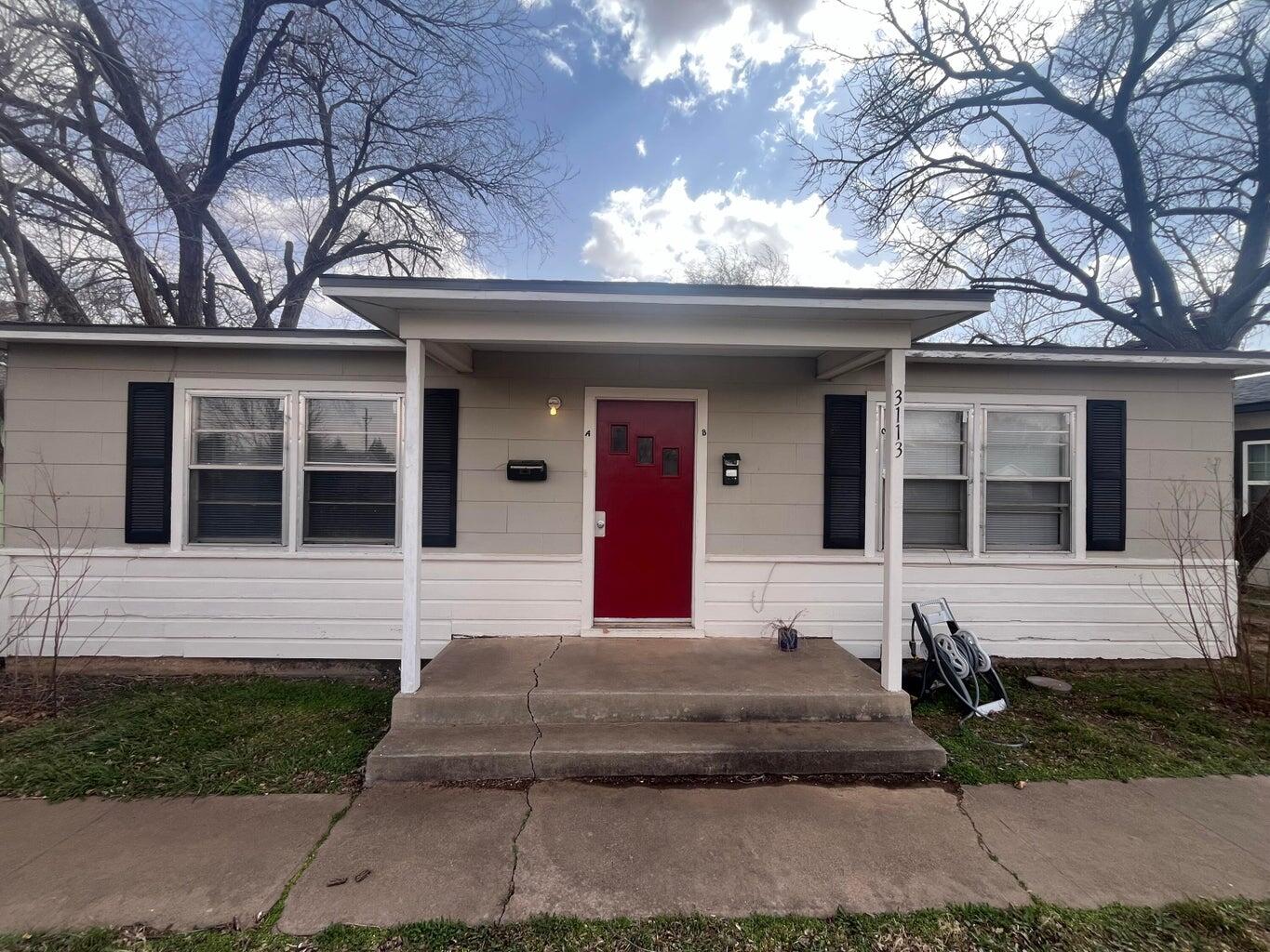 3113 33rd Street, Unit A Lubbock, TX 79410 - Photo 1 of 10 a front view of a house with yard