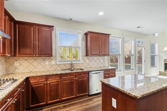 a kitchen with stainless steel appliances granite countertop a sink stove and cabinets
