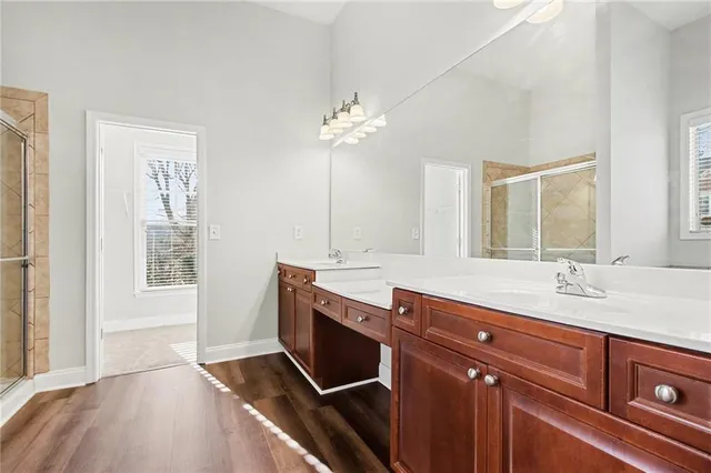 a spacious bathroom with a granite countertop sink a mirror and a bathtub