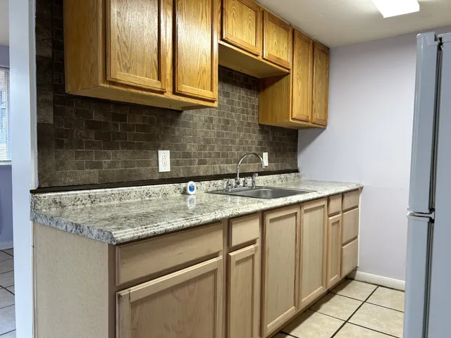 a kitchen with granite countertop a sink and cabinets