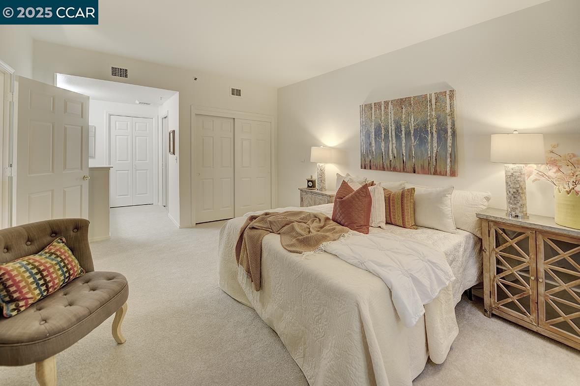 1840 Tice Creek Drive, Unit 2110 Walnut Creek, CA 94595 - Photo 20 of 43 a spacious bedroom with a bed and couch
