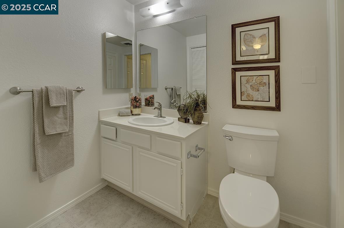 1840 Tice Creek Drive, Unit 2110 Walnut Creek, CA 94595 - Photo 4 of 43 a bathroom with a toilet sink vanity and mirror