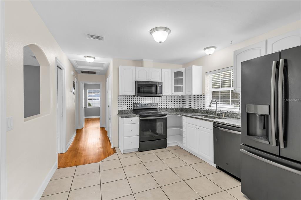 1124 Edgewater Court Orlando, FL 32804 - Photo 10 of 22 a kitchen with stainless steel appliances granite countertop a refrigerator and a stove top oven