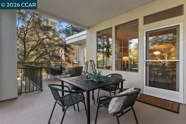 a front view of a building with a garden and trees