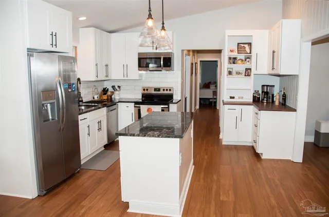 a kitchen with stainless steel appliances a refrigerator stove microwave and cabinets