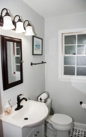 a bathroom with a sink mirror and toilet