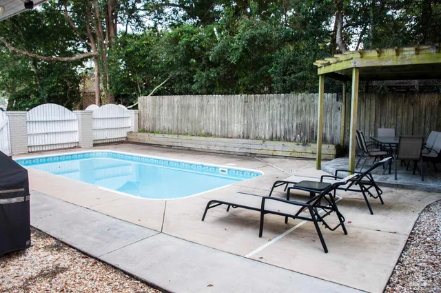 a swimming pool with outdoor seating and yard
