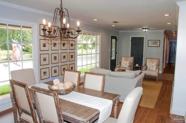 a dining room with furniture a chandelier and wooden floor