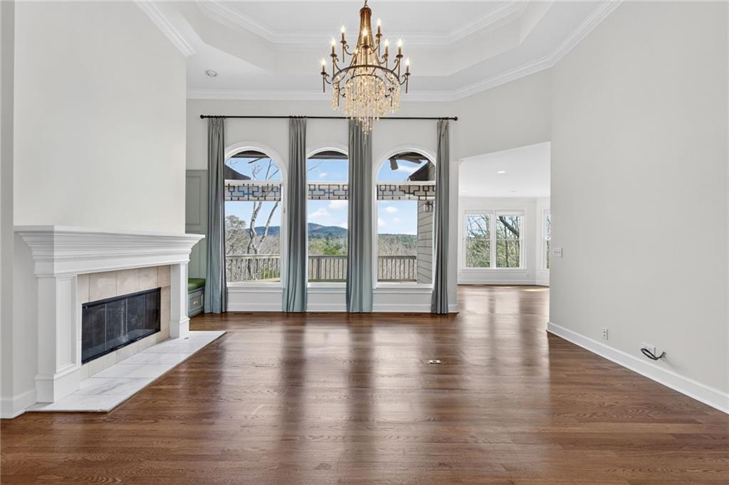 1027 Hunters Trace Jasper, GA 30143 - Photo 7 of 70 a view of an empty room with wooden floor fireplace and a window