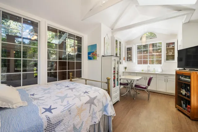 a bedroom with a bed and a flat tv screen next to a window