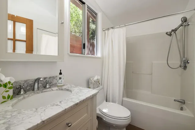 a bathroom with a granite countertop sink toilet and shower