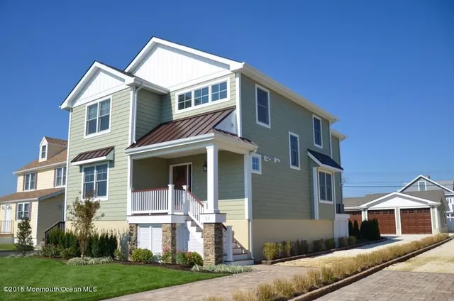 a front view of a house with a yard and trees