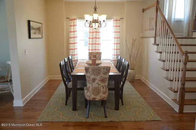 a kitchen with stainless steel appliances granite countertop a sink a stove a refrigerator and island with wooden floor