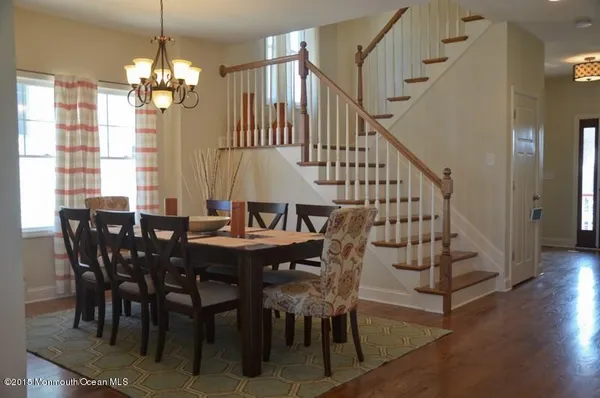 a kitchen with stainless steel appliances kitchen island granite countertop a dining table chairs refrigerator and sink