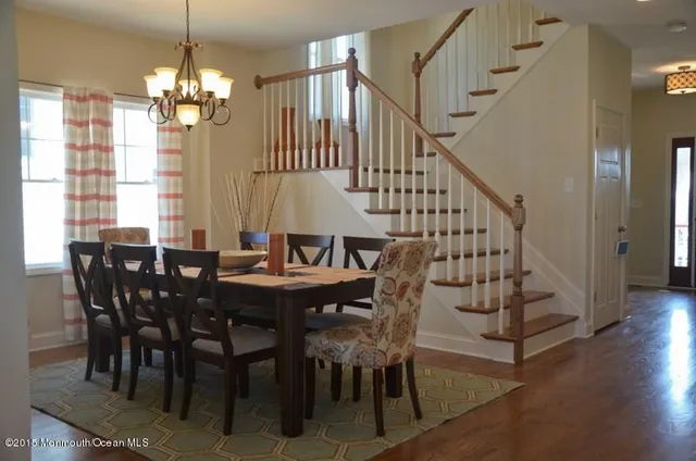 a kitchen with stainless steel appliances kitchen island granite countertop a dining table chairs refrigerator and sink