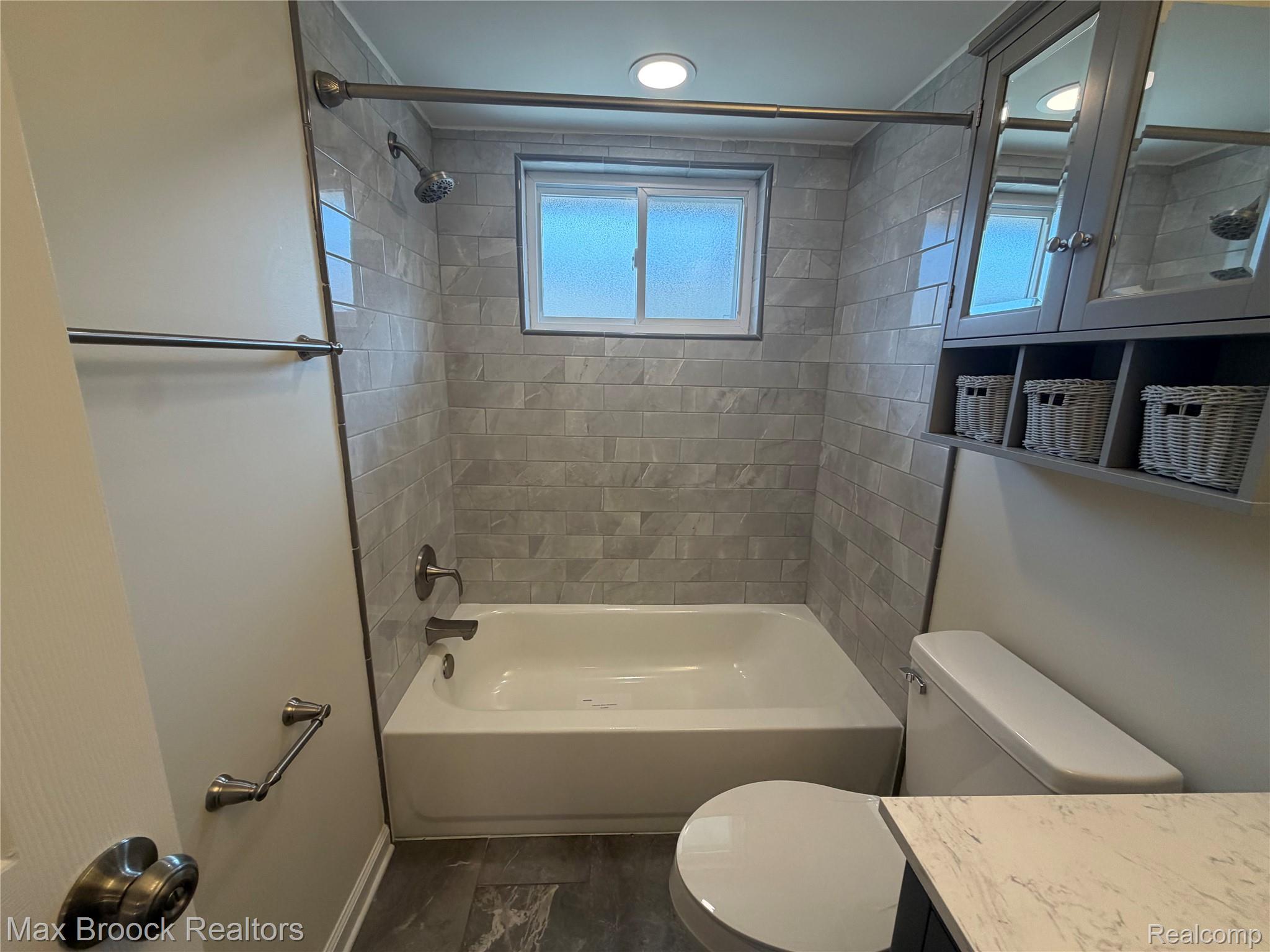 3875 Devon Road, Unit # 9 Royal Oak, MI 48073 - Photo 8 of 17 Bathroom featuring a white tub, light gray subway tile surround, frosted window, gray wood-finish vanity with mirrored medicine cabinet, and built-in shelving