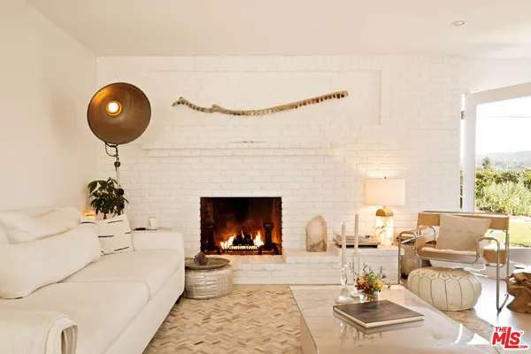 a living room with furniture a fireplace and window