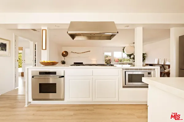 a kitchen with stainless steel appliances granite countertop a stove and white cabinets