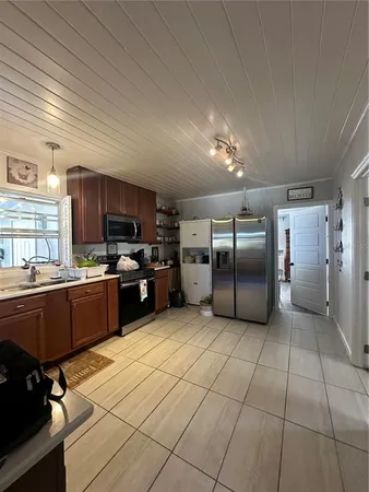 a kitchen with stainless steel appliances granite countertop a refrigerator and a stove top oven