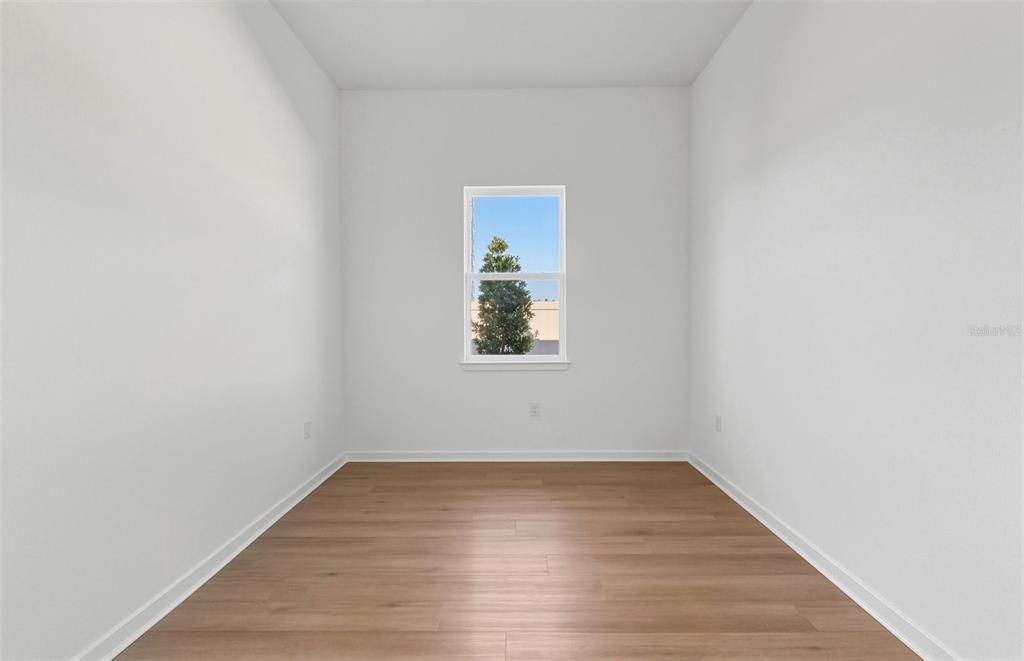 13655 Cyn Rdg Road Spring Hill, FL 34610 - Photo 13 of 28 a view of an empty room with wooden floor and a window