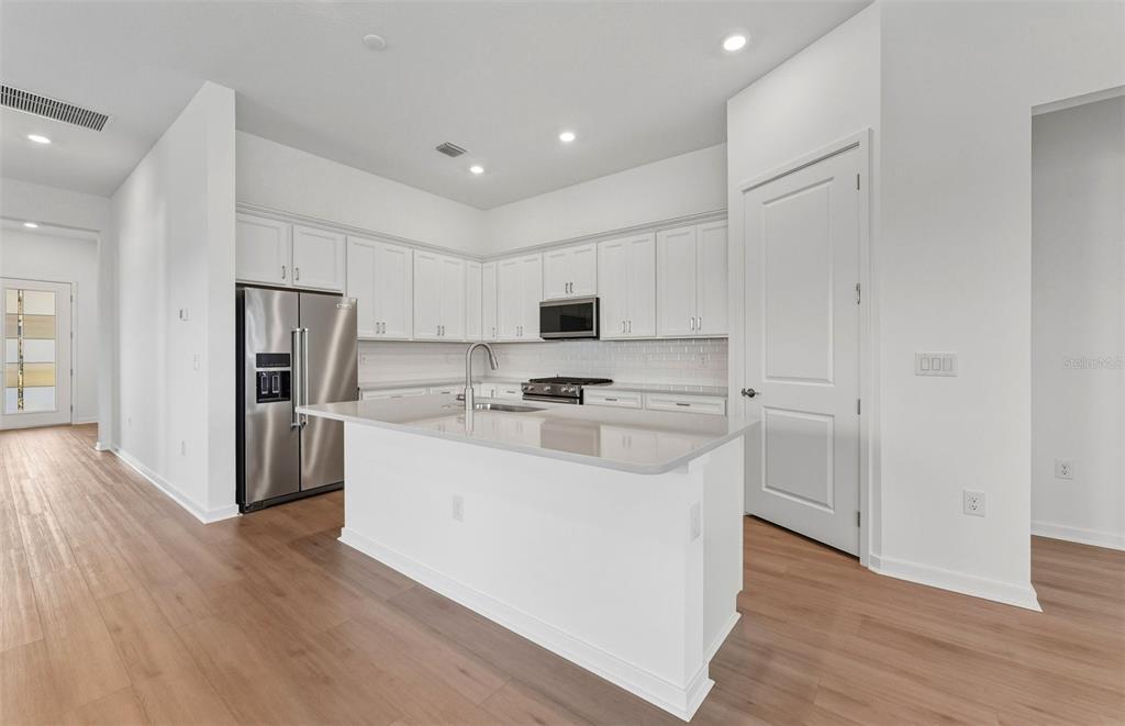 13655 Cyn Rdg Road Spring Hill, FL 34610 - Photo 3 of 28 a kitchen with stainless steel appliances a refrigerator sink and white cabinets